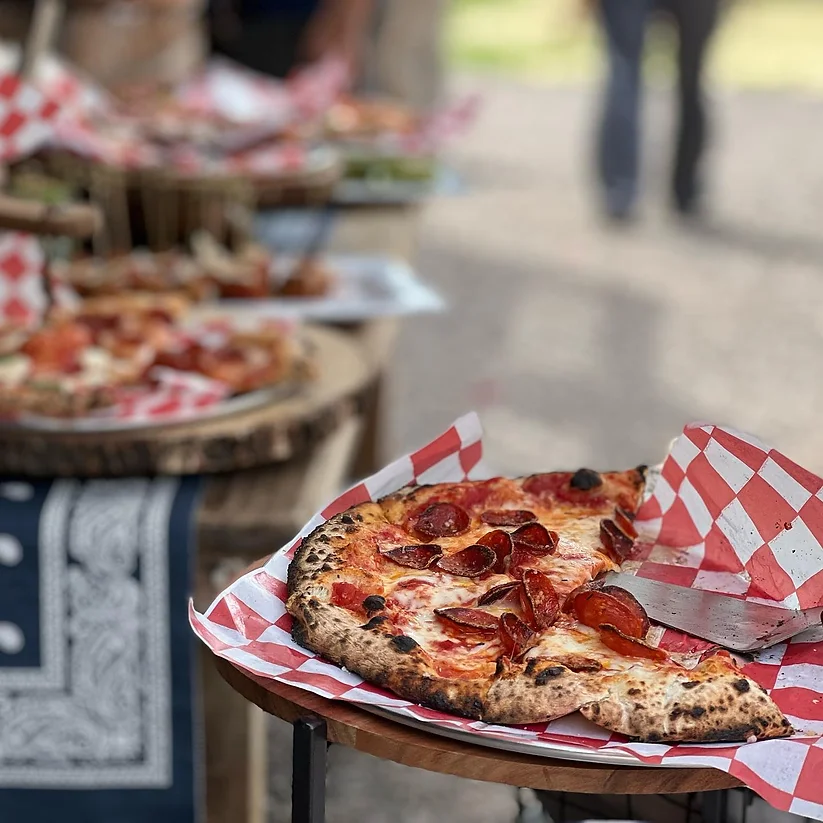 Positive young multiracial friends eating fast food and drinking beer in outdoor cafe
